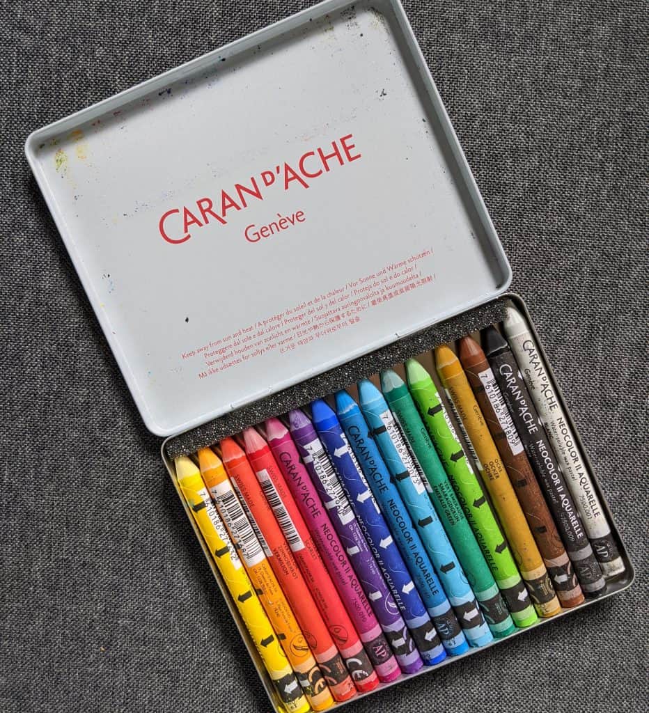 Colorful Caran d'Ache watercolor crayon set in metal tin for artists and creators.