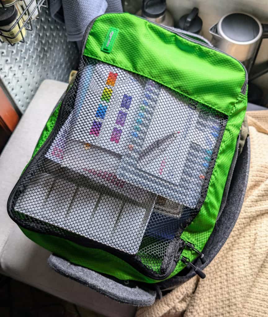 Clear medication organizing travel bag with pills and blister packs inside.